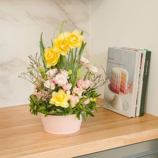 vaso con fiori gialli, bianchi e rosa sopra una mensola regalo per compleanno
