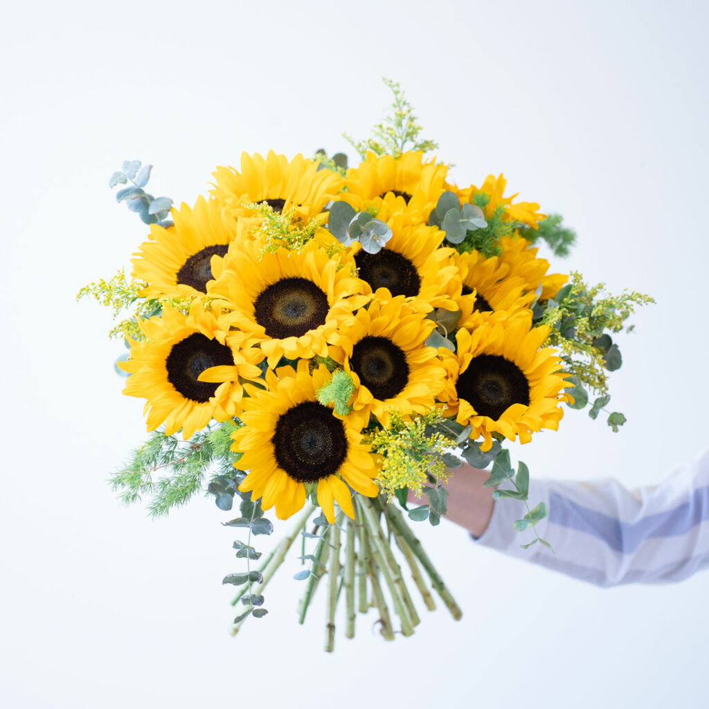 Bouquet di girasoli tenuti in mano da una persona