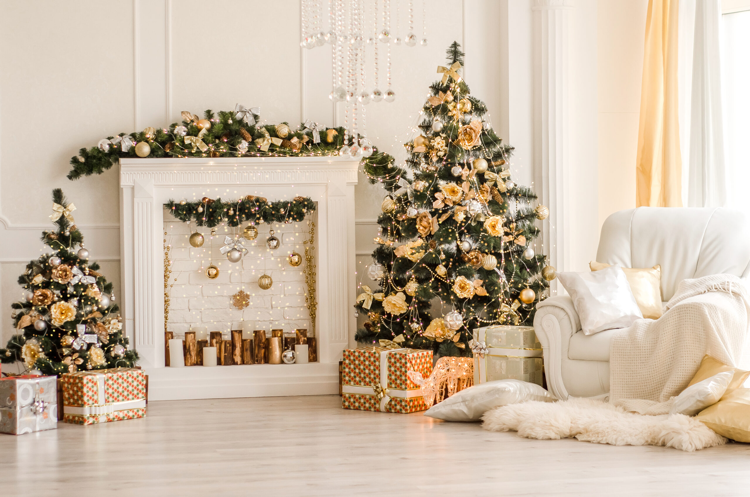 Soggiorno con toni chiari decorato per Natale con regali poggiati sotto l'albero.