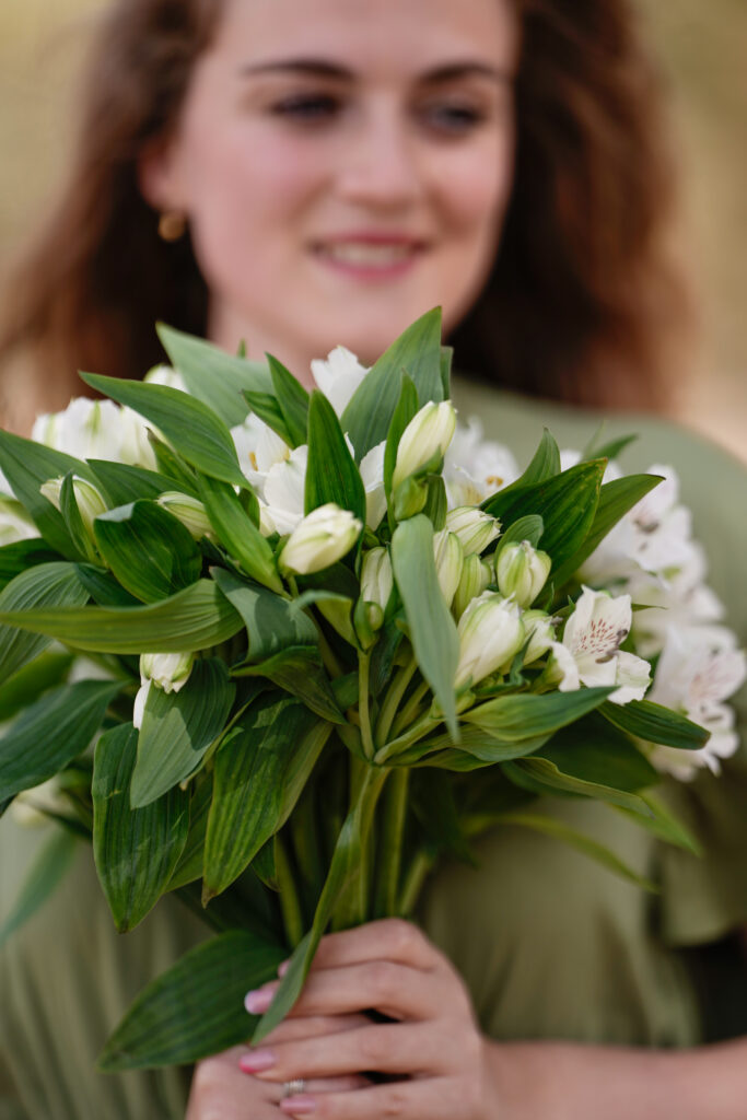 Ragazza che tiene in mano un bouquet di alstroemerie bianche