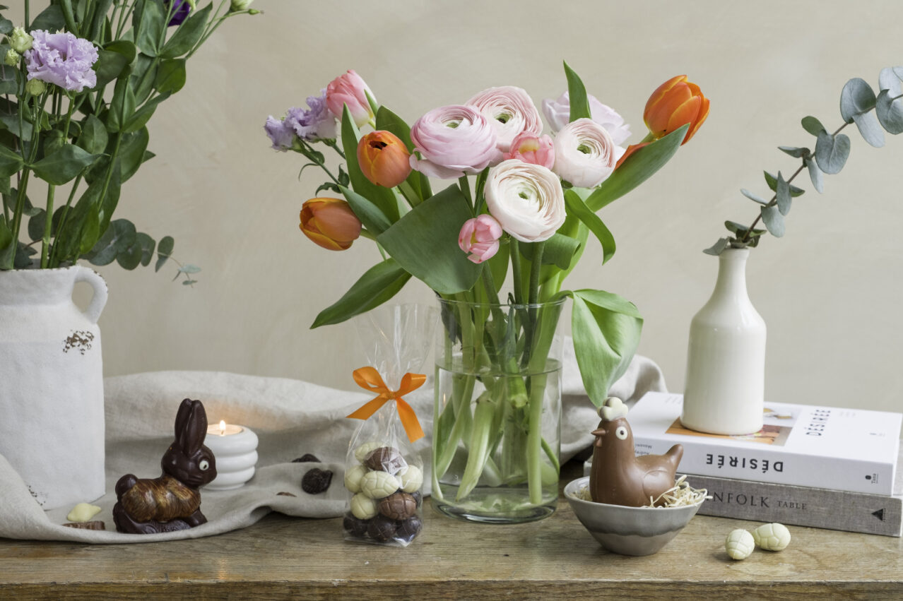 decorare il tavolo di pasqua con un bouquet di fiori e cioccolato a forma di coniglietti