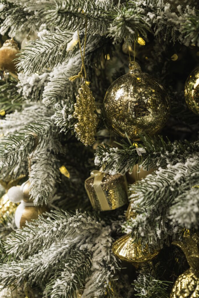 primo piano albero di Natale decorato con elementi in oro.