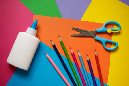 Colla, forbici, cartoncini colorati e matite colorate per creare bigliettini